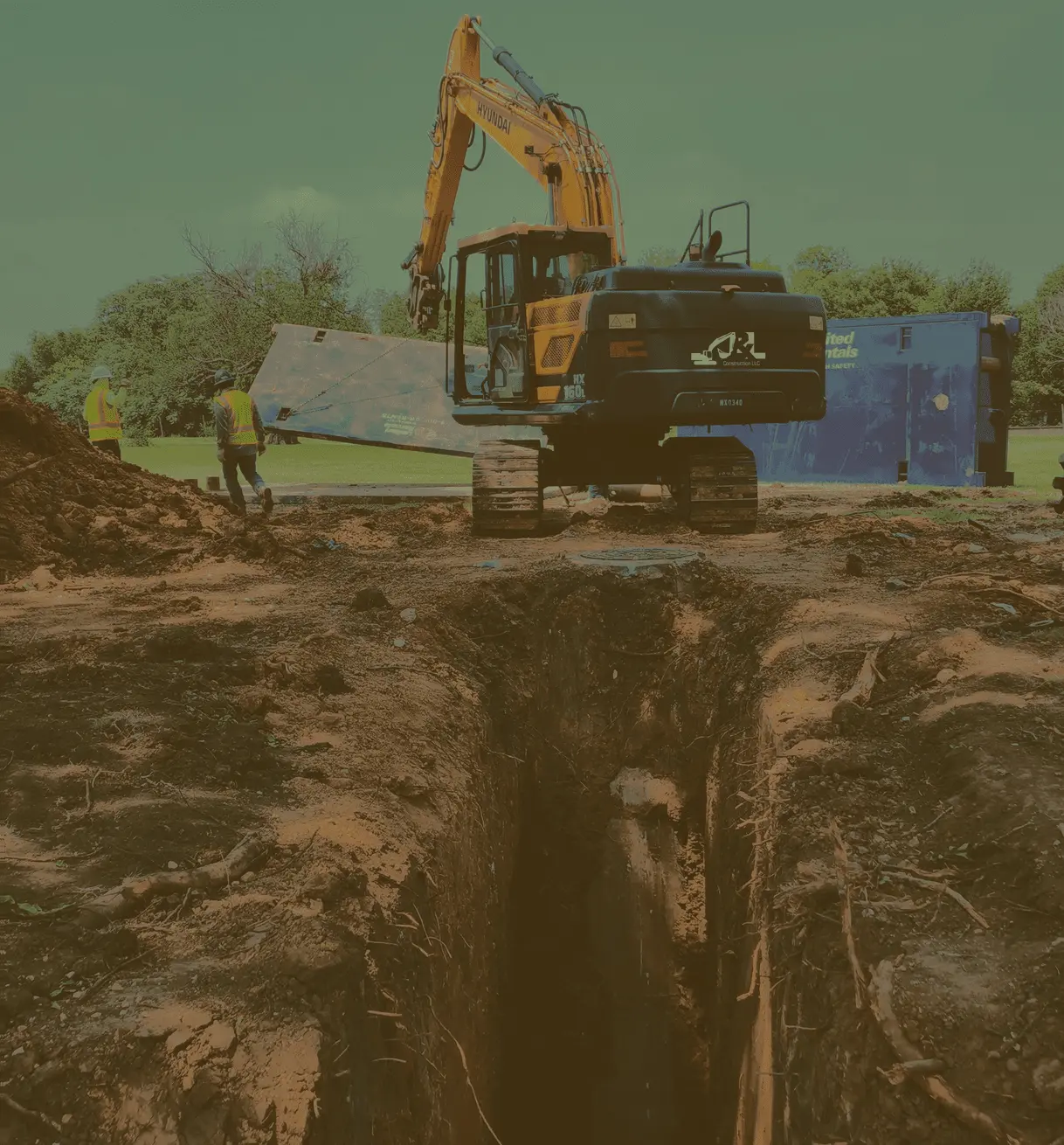 Excavator in front of a trench.