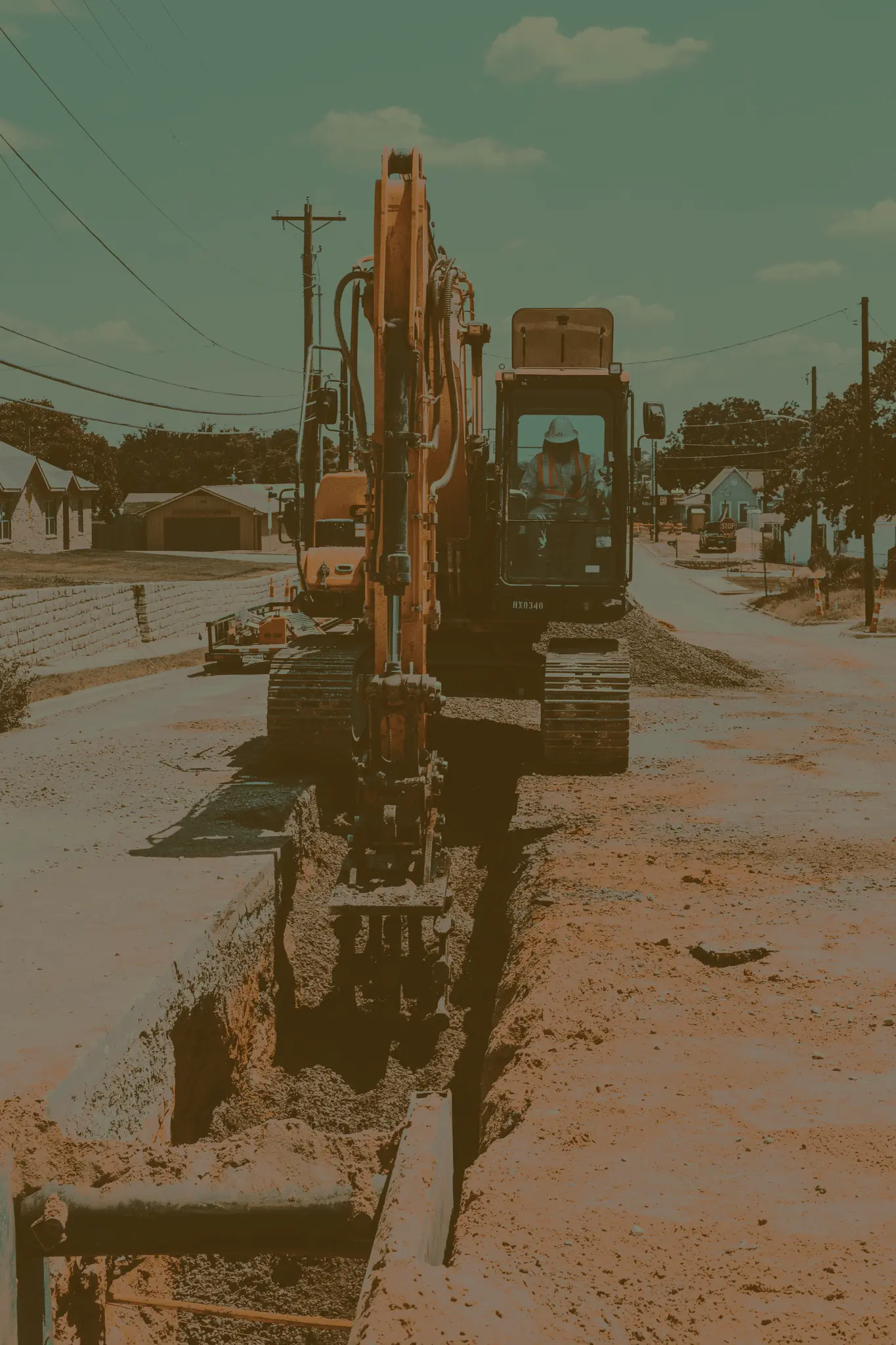 A skid-steer loading up an eighteen wheeler with dirt.